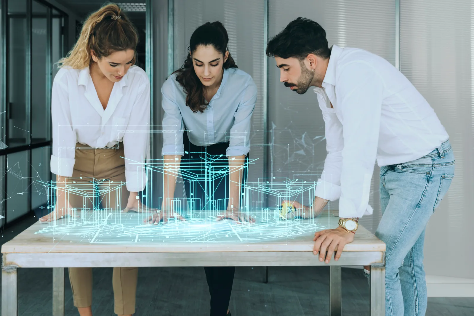 Three professionals reviewing a holographic building model on a table